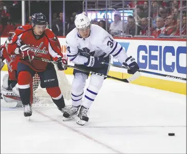  ?? The Associated Press ?? LOCKED IN: Washington Capitals defenseman Dmitry Orlov (9) battles for the puck against Toronto Maple Leafs center Auston Matthews (34) in Game 5 of their Stanley Cup first-round playoff series. Washington holds a 3-2 lead in the series, which resumes...