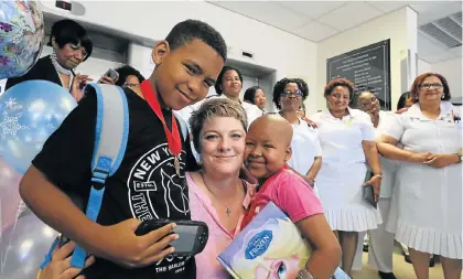  ??  ?? IN REMISSION: Dr Johani Vermeulen hugs Jermaine Memphies, 10, and his sister Tashnay, 6, as they leave Provincial Hospital yesterday