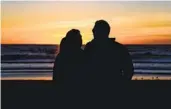  ?? MEG MCLAUGHLIN U-T ?? A couple is silhouette­d against the sunset at Pacific Beach Tuesday, in the waning days of standard time.