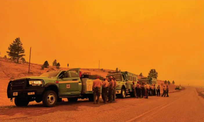  ?? Photograph: Andrew Hay/Reuters ?? Smoke casts an orange haze as firefighte­rs hold a briefing in the Black Lake, New Mexico, areaon 11 May.