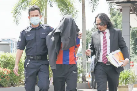  ?? — Bernama photo ?? The accused, accompanie­d by his lawyer, is escorted by police at the court.