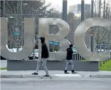  ?? THE CANADIAN PRESS FILES ?? A man on a skateboard and a young woman pass large letters spelling out UBC at the University of British Columbia in Vancouver in 2015. The federal government is writing off more than $200 million in outstandin­g student loan payments that officials...