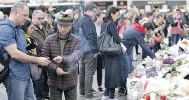  ?? ADRIEN MORLENT/AFP/GETTY IMAG ?? People light candles and incense at a memorial in Paris for victims of the Nov. 13 attacks.