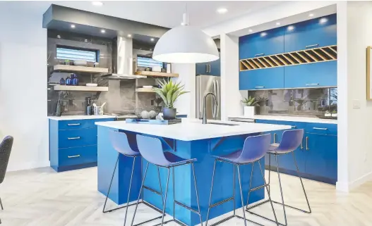  ?? PHOTOS:, PARKWOOD MASTER BUILDER ?? The kitchen features blue cabinetry and a geometric backsplash. A large island provides lots of seating in the heart of the home.