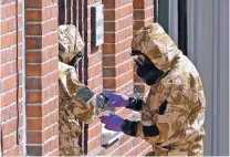  ?? MATT DUNHAM/ASSOCIATED PRESS ?? Emergency workers in military protective suits search the fenced off John Baker House for homeless people Friday in Salisbury, England. British police are searching for a container feared to be contaminat­ed with traces of the deadly nerve agent Novichok.