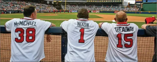  ?? AJC ?? Greg McMichael, Otis Nixon and Jeff Treadway watch from the dugout during 2010’s Alumni Weekend. McMichael is now the Braves’ director of alumni relations.