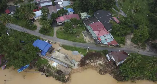 ?? ?? TINJAUAN tebing sepanjang 20 meter yang dibina oleh Jabatan Pengairan dan Saliran (JPS) runtuh termasuk dua jeti yang dibina penduduk kampung turut hanyut akibat hakisan selepas banjir teruk. Lebih 200 penduduk di Kampung Pulau Pisang hidup ketakutan apabila tebing sungai di kampung berkenaan runtuh akibat hakisan sejak awal bulan ini. - Gambar NSTP/NIK ABDULLAH NIK OMAR