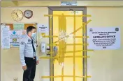  ?? AFP ?? A security guard stands outside a room storing ballot boxes at a junior high school ahead of the presidenti­al election in Manila.