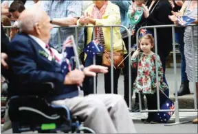  ?? PETER PARKS/AFP ?? A young girl looks at a war veteran as he passes by in the Anzac Day parade in Sydney yesterday.