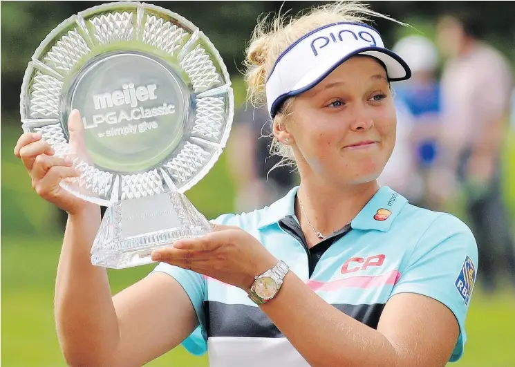  ?? — AP PHOTO ?? Canada’s Brooke Henderson with the winner’s trophy after capturing the Meijer LPGA Classic by two strokes Sunday: ‘It was just like the perfect day,’ she said.