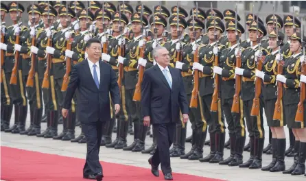  ?? — AFP ?? Brazil’s President Michel Temer (R) reviews an honour guard with Chinese President Xi Jinping during a welcome ceremony outside the Great Hall of the People in Beijing on Friday. Temer is on a state visit to China and will attend the BRICS Summit in...