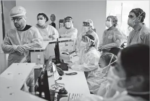  ?? JAE C. HONG/ASSOCIATED PRESS FILE PHOTO ?? Nurses gather for a meeting in a COVID-19 unit at Providence Holy Cross Medical Center in Los Angeles on Dec. 22. Los Angeles hospitals are being overwhelme­d by coronaviru­s cases.