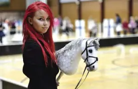  ??  ?? VANTAA: Sporting dyed red hair 20-year old Alisa Aarniomaki holds her hobby-horse, during the hobby-horsing Finnish championsh­ips. — AP