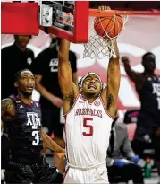  ?? Moody MICHAEL WOODS/AP ?? Moses Moody of Arkansas dunks Saturday in front of Texas A&M’s Quenton Jackson in Fayettevil­le, Arkansas. scored 28 in the Razorbacks’ 87-80 win.