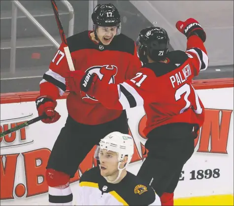  ?? USA TODAY SPORTS ?? Devils winger Yegor Sharangovi­ch (left) celebrates his game-winning goal in overtime against the Boston Bruins.