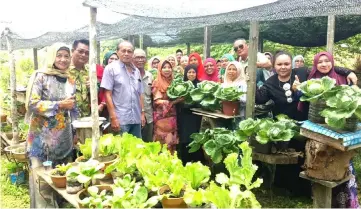  ??  ?? Rosey (fifth left) and Sawal (fourth left) with PBB Bekenu Women members during the visit to Sawal’s farm near his house.