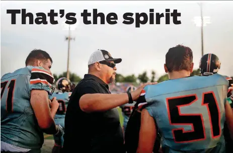  ?? [PHOTOS BY SARAH PHIPPS, THE OKLAHOMAN] ?? The Rev. Mike Keahbone, senior pastor of Cherokee Hills Baptist Church, talks with Putnam City High School football players on the sidelines at a Sept. 7 game at Putnam City Stadium in Oklahoma City.