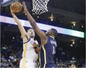  ??  ?? OAKLAND: Golden State Warriors’ Klay Thompson, left, lays up a shot against Indiana Pacers’ Kevin Seraphin (1) during the third quarter of an NBA basketball game Monday, in Oakland, Calif. — AP