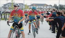  ?? SCOTT ROSTS METROLAND ?? St. Martin Catholic Elementary School students welcome dozens of riders participat­ing in the Cops for Cancer charity ride.