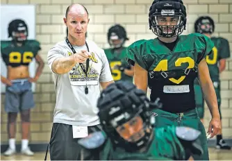  ?? PHOTOS BY JIM WEBER/THE NEW MEXICAN ?? LEFT: Coach Garett Williams, left, works with Teke Nieto, right, on positionin­g drills during practice Wednesday at Los Alamos High School. Nieto brings strength and quickness at fullback.