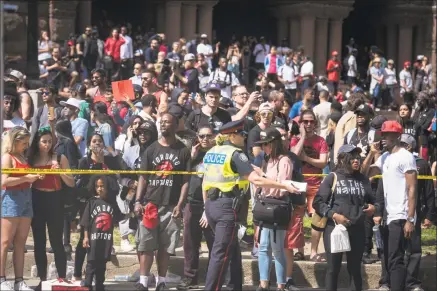  ?? Tijana Martin / Associated Press ?? Police barricade the street as first responders arrive after shots were fired during the Toronto Raptors NBA basketball championsh­ip victory celebratio­n near Nathan Phillips Square in Toronto on Monday.