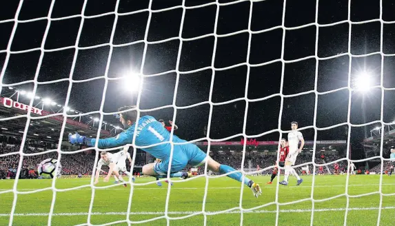  ??  ?? > Alfie Mawson looks as Benik Afobe’s strike cannons off his legs into the Swansea City net