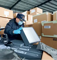  ?? Photos by Bai Guibin ?? Customs officers checking a shipment of women’s shoes that will be exported to Europe from the Chengdu Railway Port on February 10, 2020.