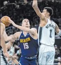  ?? Stephen Spillman The Associated Press ?? Nuggets center Nikola Jokic eyes the basket against Spurs center Victor Wembanyama in Denver’s victory Friday at the Moody Center.