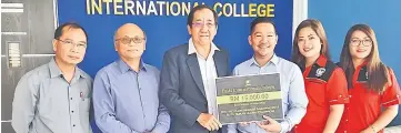  ??  ?? Tham (third from left) hands over a mock cheque for RM15,000 as the first prize for the Ruran Ulung pageant to Petrus witnessed by (from left) Lah Kebing, Ricky, Corlina and Patricia.