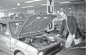  ?? DIANNE KELLEY / THE TENNESSEAN ?? Kirk Johnson, sales manager at Star Chrysler-plymouth, here Feb. 26, 1986, says shoppers should remember they are looking at a $4,000 car when they examine the Yugo, the subcompact cars made in Yugoslavia, that have arrived in Nashville. Star Chrysler-plymouth is the only Yugo car dealership in Nashville.