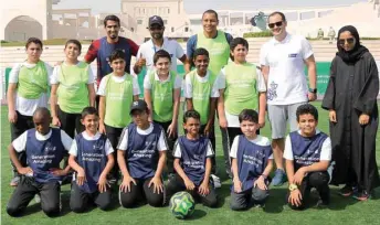  ??  ?? Mohamed Saadon al-Kuwari (left, back) and Gilberto da Silva (third from left, back) with their young teammates and members of Generation Amazing.