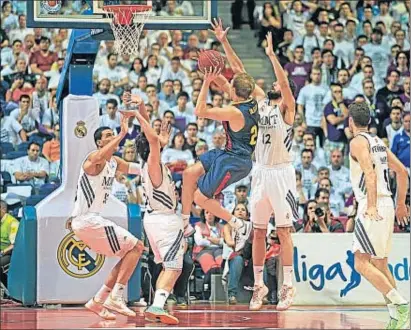  ?? VÍCTOR LERENA / EFE ?? Oleson llança a cistella en presència de Mirotic i Llull en el partit de dijous passat