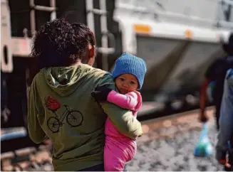  ?? Marco Ugarte/Associated Press ?? Migrants walk near tracks in hopes of boarding a freight train heading north in Huehuetoca, Mexico, on Friday, one day after the U.S. ended Title 42, a pandemic-era border restrictio­n.