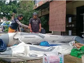  ?? (Foto Omar Ahmad/bh) ?? Mohd Afiq (kanan) dan Yuzaini melihat kebocoran pada bot getah ketika ditemui di Villa Ros Taman Tampoi Indah, semalam.