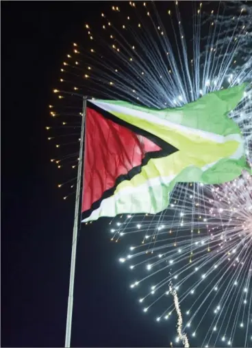  ??  ?? The Golden Arrowhead: The raised flag of Guyana lit up by fireworks at last night’s Republic anniversar­y celebratio­ns at D’Urban Park.