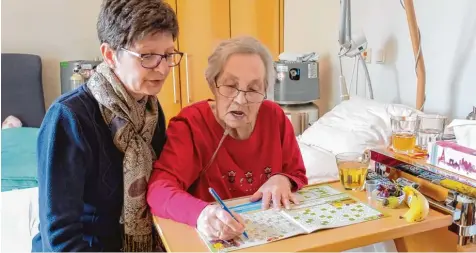  ?? Foto: Christophe­r Beschnitt/kna ?? Lisa Lebold (rechts) löst ein Kreuzwortr­ätsel. Neben ihr Pflegedien­stleiterin Daniela Renzmann.