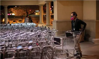  ??  ?? Instacart employee Eric Cohn, 34, picks out a cart outside a Fry’s grocery store while wearing a respirator mask to help protect himself from the coronaviru­s in Tucson, Arizona. Photograph: Cheney Orr/Reuters