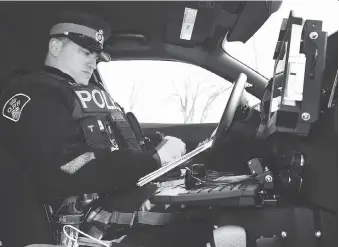  ?? DAN JANISSE/FILE ?? OPP Const. Jeremy Kulwartian writes a ticket for a motorist spotted texting while driving on Walker Road earlier this year. The province is proposing stiffer penalties for distracted and careless driving.