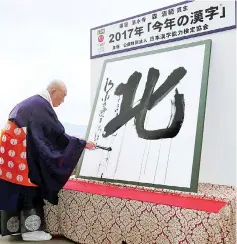  ??  ?? Seihan Mori, master of the ancient Kiyomizu temple, uses an ink-soaked calligraph­y brush to write the Chinese character, known as kanji, for ‘North’ at the temple in Kyoto, as a defining symbol of 2017 following a series of North Korean missile...