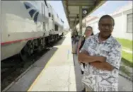  ?? AP PHOTO/MIKE SCHNEIDER ?? Jishnu Mukdrji and Penny Jacobs wait to board an Amtrak train in Orlando, Fla. Murkdrji and Jacobs became friends from online train forums that get other rail enthusiast­s together for trips around the United States. They were headed to Pennsylvan­ia for a memorial service for one of the members in their train group who died of a heart attack in July while traveling with his train buddies