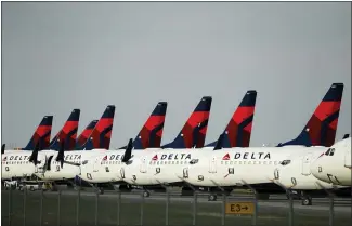  ?? CHARLIE RIEDEL — THE ASSOCIATED PRESS FILE ?? Mothballed Delta Air Lines jets are parked in April at Kansas City Internatio­nal Airport in Missouri. More airlines are restoring flights to their schedules and investors have taken note, driving up shares for the major airlines after a staggering decline.