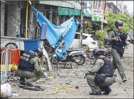  ??  ?? Thai policemen inspect the site of a bombing in Pattani yesterday.