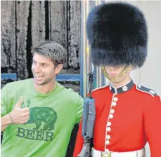  ?? FOTO: MARK RALSTON/AFP ?? Ein Tourist posiert für ein Foto mit einem Soldaten der königliche­n Garde: Es gilt als unwahrsche­inlich, dass Deutsche künftig ein Visum für die Einreise nach Großbritan­nien benötigen.