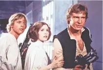  ?? LUCASFILM LTD. ?? Carrie Fisher (center) starred alongside Mark Hamill (left) and Harrison Ford in the original “Star Wars.”