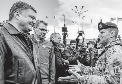  ?? FOTO REUTERS ?? Američané na Ukrajině. V roce 2015 pozdravil tehdejší ukrajinský prezident Petro Porošenko účastníky společného vojenského cvičení americké a ukrajinské armády ve Lvovské oblasti. Vysílání svých specialist­ů na Ukrajinu ukončily země NATO po únoru 2022, kdy zemi napadlo Rusko.