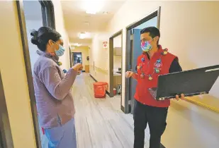  ?? AP FILE PHOTO ?? ABOVE: Dr. Cristina Toledo-Cornell, left, shares a socially distanced fist bump with Dr. Dakotah Lane after the first COVID-19 vaccinatio­n was given to a Lummi Nation tribal member Dec. 17 on the Lummi Reservatio­n near Bellingham, Wash.