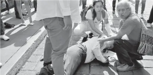  ?? FOTO: AGENCIAS ?? > Una de las víctimas del tiroteo se encuentra tirada en el suelo, mientras tratan de prestarle ayuda.