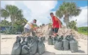  ?? [JOHN RAOUX/ THE ASSOCIATED PRESS] ?? Residents of Flagler Beach, Fla., fill sandbags Friday to help protect their homes in preparatio­n for Hurricane Dorian.