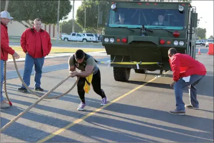  ??  ?? A COMPETITOR TESTS HIS STRENGTH in the truck pull.