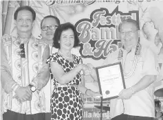  ??  ?? Catherine represente­d her late father Peter Lupang Tingkalus in receiving the certificat­e of appreciati­on as bamboo pioneer, from Pairin.